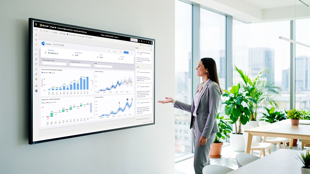 Businesswoman presenting a sales dashboard on a large wall-mounted screen